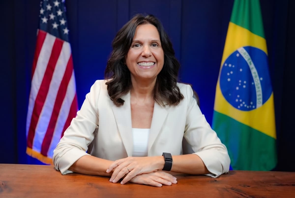 Professora Claudia, com as bandeiras dos Estados Unidos e do Brasil